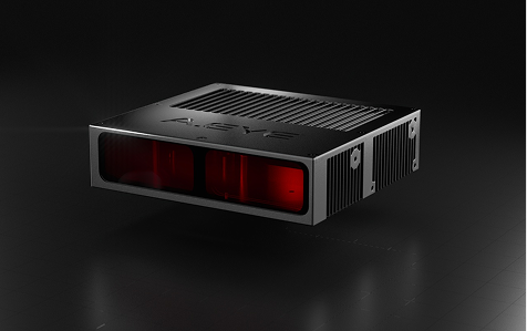 A sleek, rectangular black electronic device with red-tinted front panel and ventilation grilles, placed on a dark reflective surface.